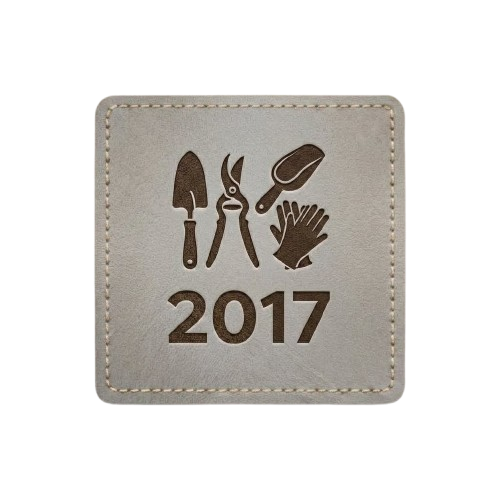 Gray square patch with stitched border. Features a silhouette of a hand trowel, pruning shears, and gardening gloves with the text "2017."